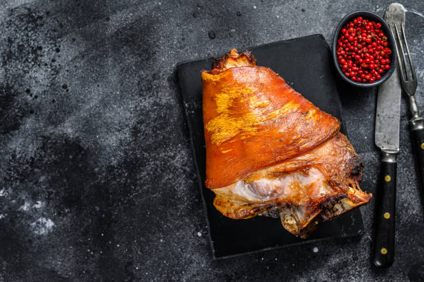 istock Roast pork knuckle with pink pepper and spices. Black background. Top view. Copy space 1290549061