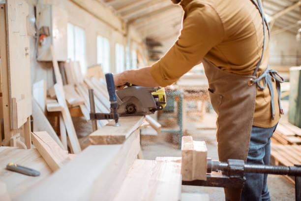 istock Carpenter sawing wooden bars indoors 1290549356