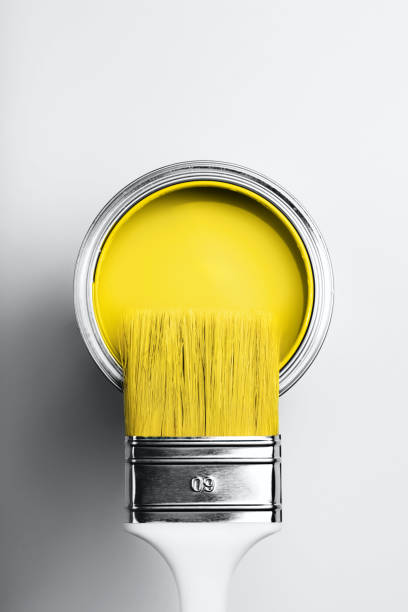 istock Brush on open can of yellow paint 1290549458