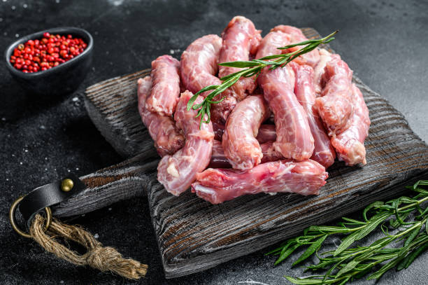 istock Raw chicken neck meat on a cutting board. Black background. Top view 1290549484