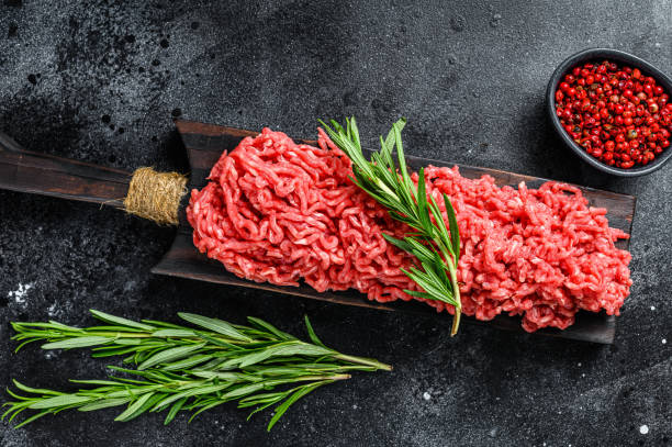 istock Fresh Raw mince beef, ground meat with herbs and spices. Black background. Top view 1290549842