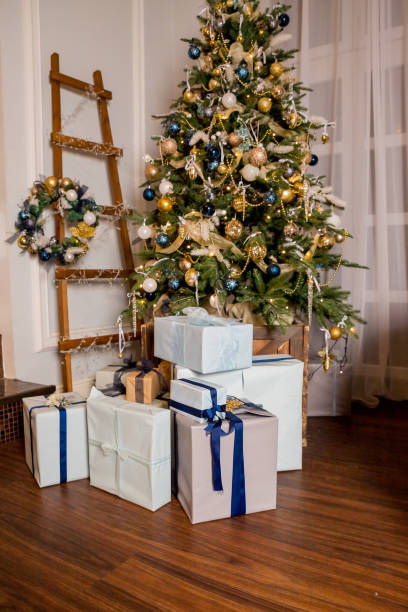 istock living room with a Christmas tree and decorations. cozy and warm evening.Interior design, tree decorated by presents, gifts, toys, candles, lanterns, garland .holiday living room. New year holidays 1290550776