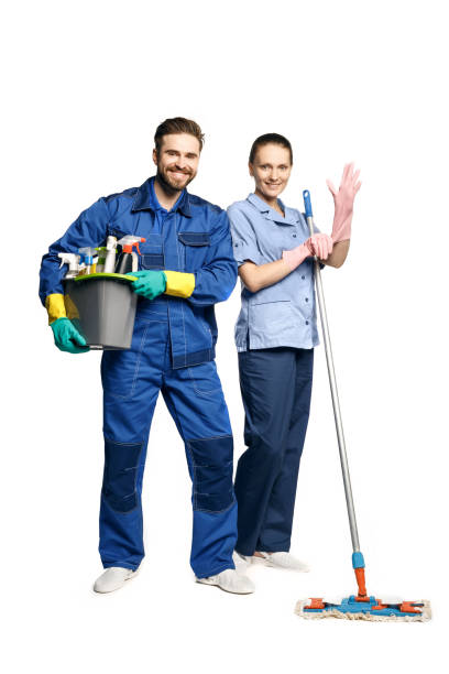 jeune femme et homme attirants dans l’uniforme de nettoyage et les gants en caoutchouc retenant une vadrouille et un seau des produits de nettoyage dans ses mains, isolés sur le fond blanc. - protective glove washing up glove cleaning latex photos et images de collection