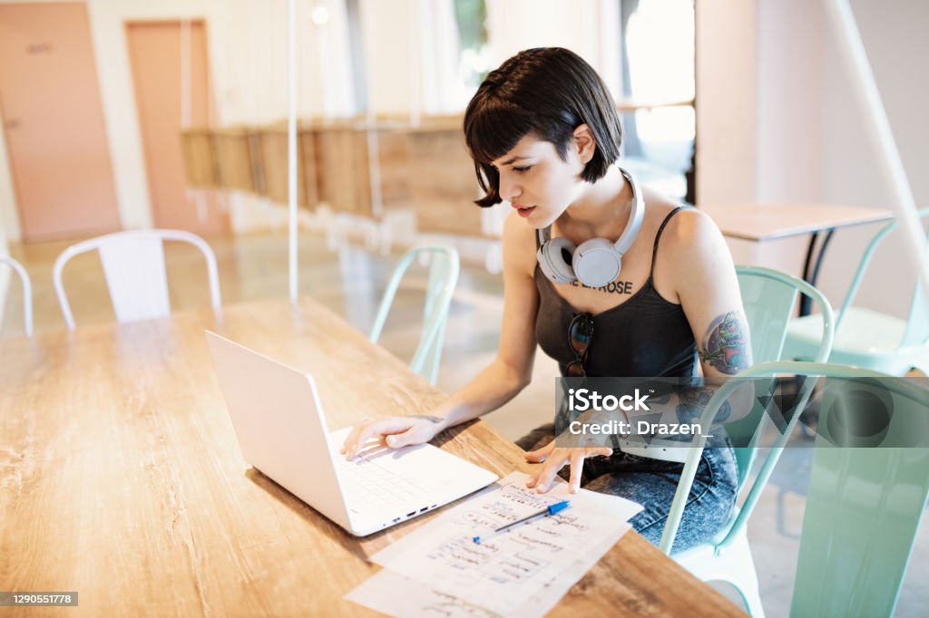 Young Latin business people working in modern coworking space - reopening business after coronavirus Freelancers working in modern coworking cafe Tattoo Stock Photo