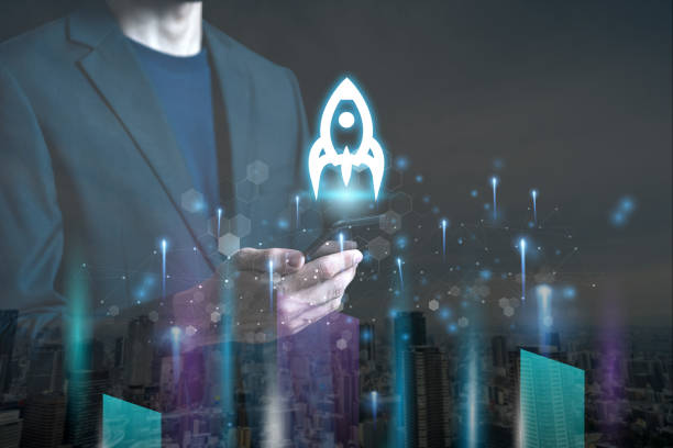 istock Startup concept with businessman holding tablet or smartphone transparent rocket in launching with network connection on modern virtual interface.StartUp Programming Team.Website designer working. 1290552103