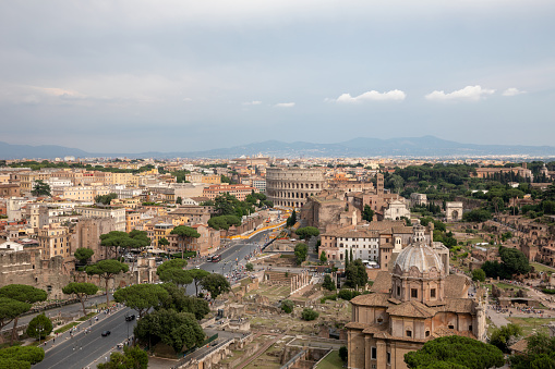 Panoramic view of city Rome with Roman forum and Colosseum from Vittorio Emanuele II Monument also known as the Vittoriano. Summer sunny day and dramatic blue sky