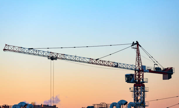 istock Silhouette of tower crane on construction site 1290553503