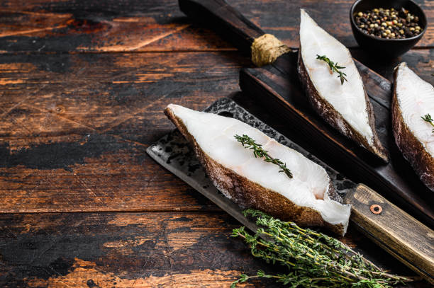 istock Raw halibut fish steak. Dark wooden background. Top view. Copy space 1290553788