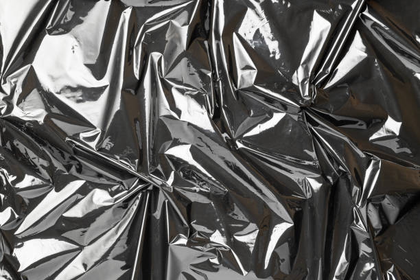 istock Plastic black background. Wrap transparent dark cellophane. Black shiny film bag pattern. Real texture of polyethylene foil. 1290554882
