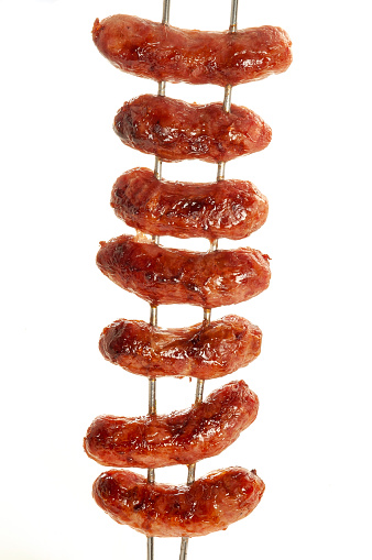 On white background scene of fresh swine sausage on board