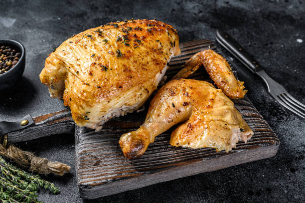 istock Butchered  grilled whole chicken.  Black background. Top view 1290555052