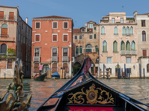 Panoramic view of Venice grand canal with historical buildings and gondolas from other gondola. Summer sunny day and sunset sky