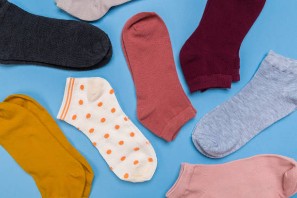 istock Many multicolored new socks stacked against a blue background. top view. place for text. 1290559812