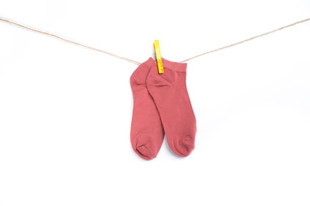 istock pink sock hanging on a rope with clothespins isolated on white background 1290559912