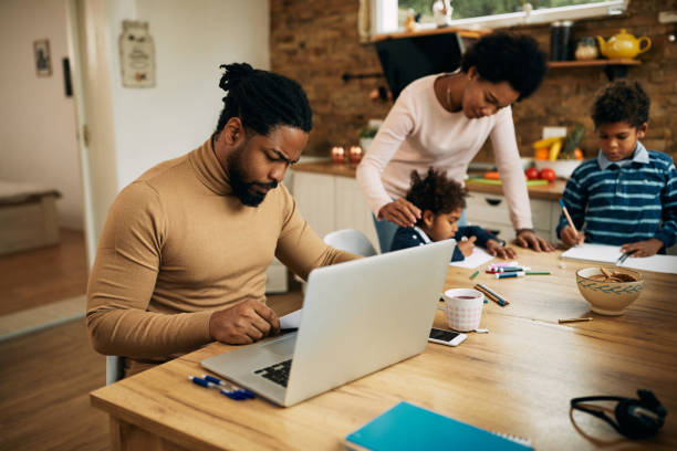 istock African American father examining reports while working on laptop at home. 1290560532