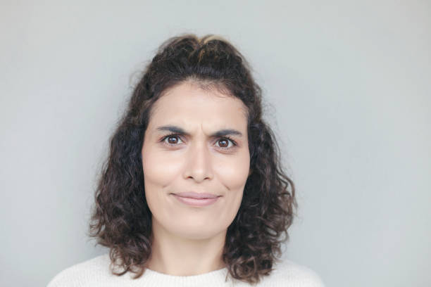 istock Young woman face expression on gray background. 1290561344
