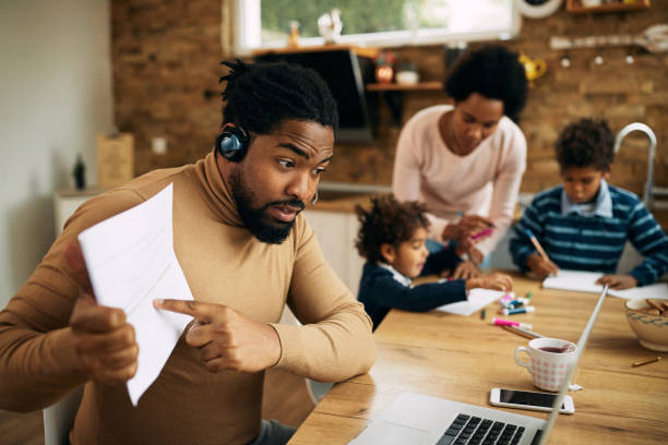 istock Black father analyzing business graphs during video call from home. 1290561388
