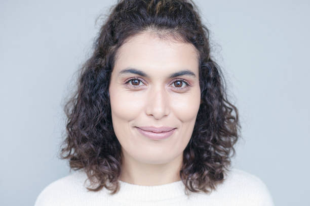 istock Young woman face expression on gray background. 1290561428