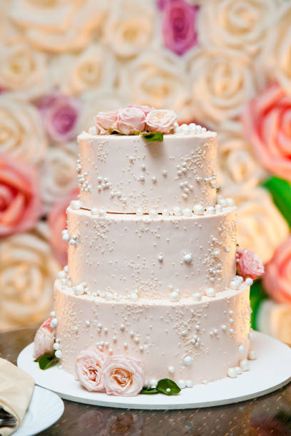 istock The wedding cake. White cake decorated with roses. 1290561452