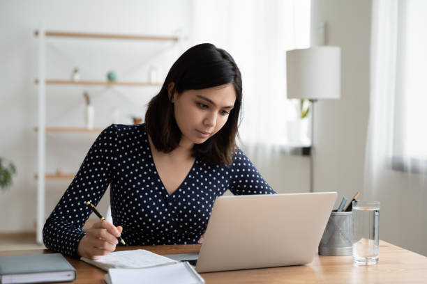 istock Confident Asian businesswoman working on laptop, writing notes 1290561591