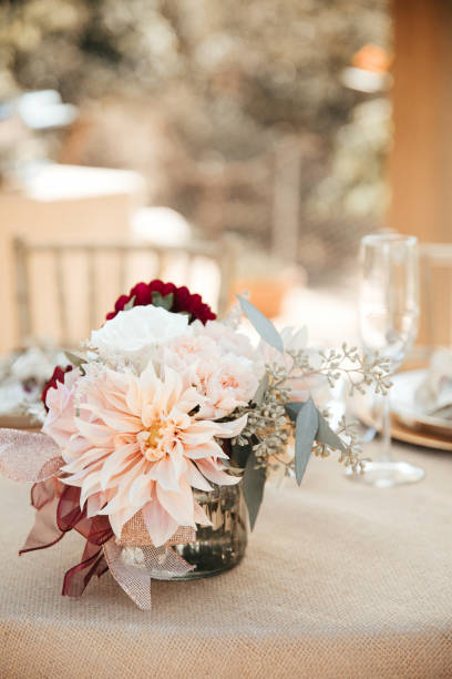 matrimonio rustico in cortile - tavoli da ricevimento con piatti e sedie dorati, dalie, peonie e foglie di eucalipto e anelli di tovagliolo di corda di iuta. - wedding centerpiece foto e immagini stock