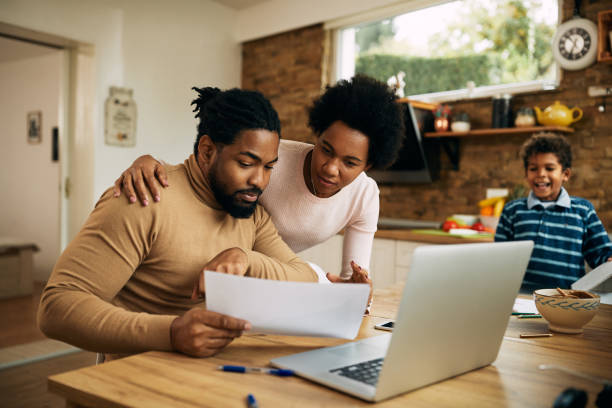 istock African American parents analyzing paperwork together at home. 1290561894