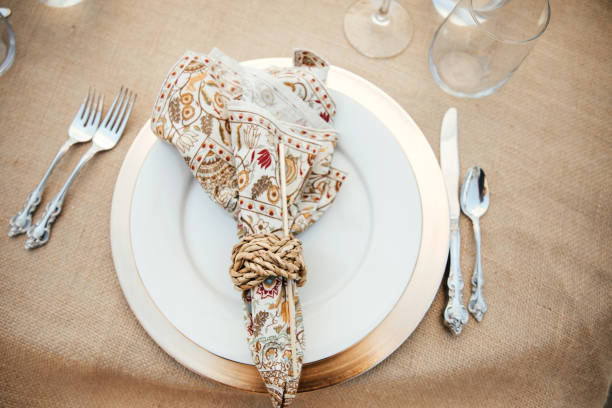 Rustic backyard wedding - reception tables with golden plates and chairs, dahlias, peonies and eucalyptus leaves and jute rope napkin rings.