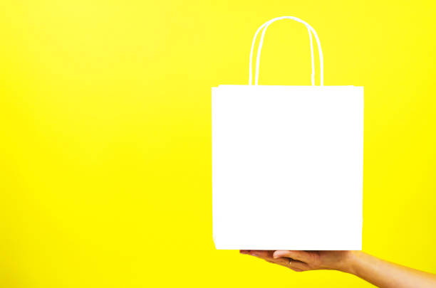 istock White paper bag on a female hand 1290562756