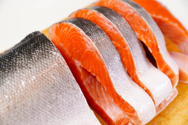 istock salmon sliced into pieces on a wooden cutting Board. red fish. 1290563277