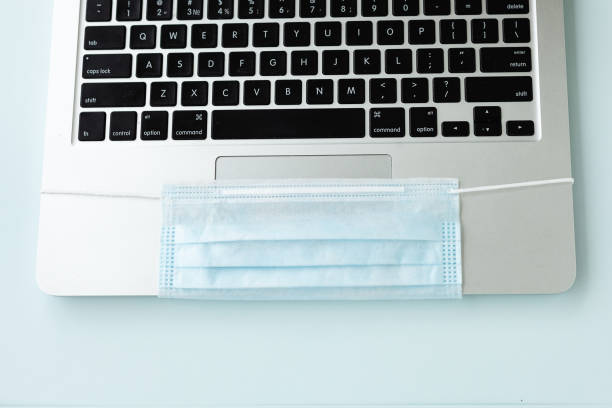 istock Coronavirus Covid-19 Prevention. Remote work or learning in quarantine. laptop and antiviral medical mask. Surgical protective mask. 1290564042