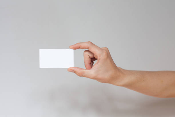 istock Hand holding empty white business card. 1290564058
