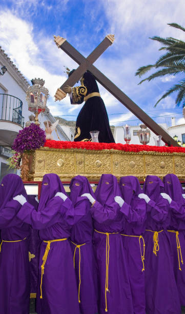 Nazarene with tunics carrying the throne Mijas, Andalusia, Spain.  April 9th, 2009.   Nazarenes carrying the throne of Jesus Christ with the cross during a daytime procession in Mijas grape hyacinth photos stock pictures, royalty-free photos & images