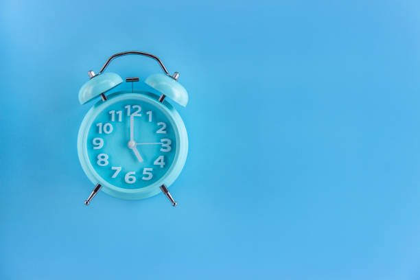 istock Blue alarm clock on blue background. Top view. Copy space for text. 1290564915