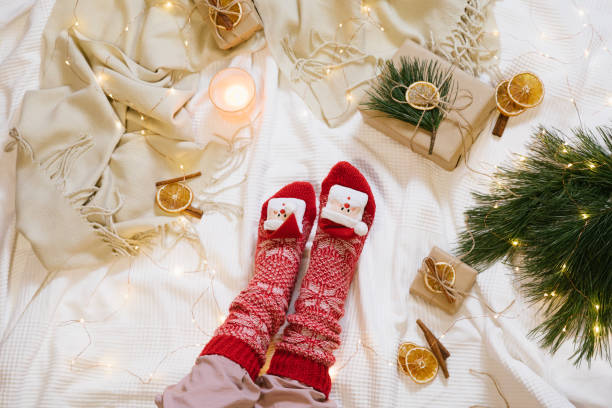 istock Warm and cozy home atmosphere preparing for holidays and celebration. Christmas composition. Wool socks, knitted blanket, gifts and christmas tree. Top view, flat lay. 1290567414