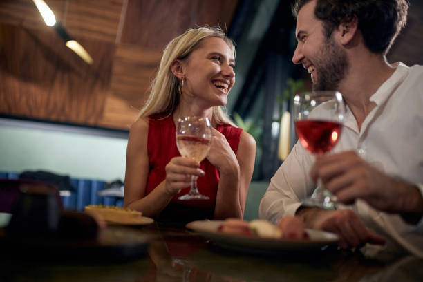 istock young couple looking each other, smiling, laughing,  having romantic dinner in a restaurant. 1290571216