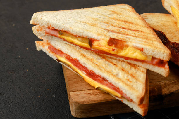 istock Triangle toasted sandwich on wooden board close up 1290572447