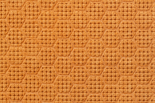 Textura de cuero de gamuza genuina en relieve patrón geométrico de primer plano, parece un panal marrón. Fondo natural moderno photo