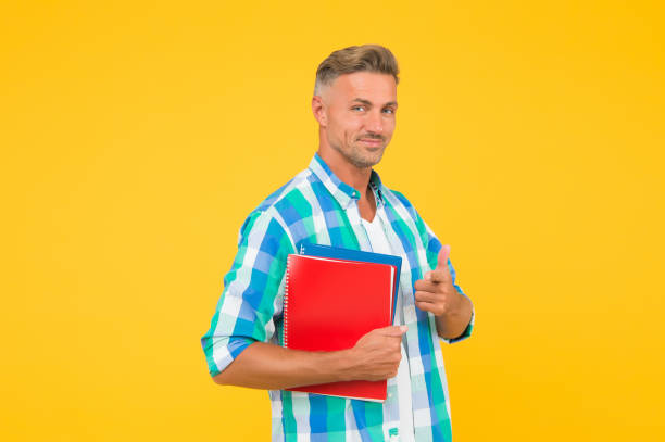 istock Keep learning all life. College university education. Man adult student. Final exam and graduation. Dedicated to studying. Student with textbooks. Regular student carry workbooks. Student life 1290574313