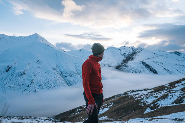 istock Trail runner relaxes on snowy mountain ridge in the morning 1290576408