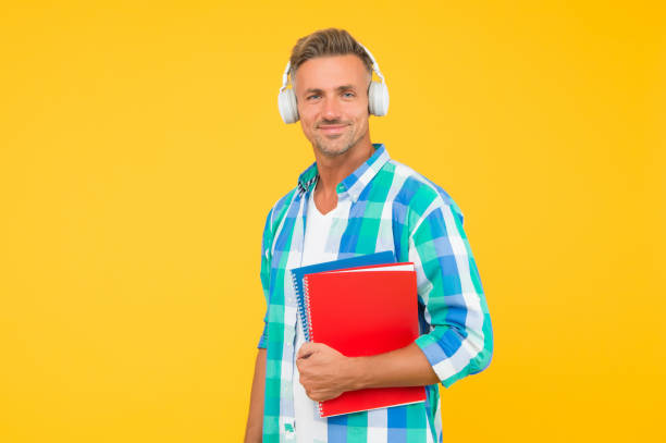istock Free courses. Audio courses. Learning english. Modern technology. Audio book concept. Worldwide knowledge access. Audio library. Man handsome student wear headphones hold books. Study languages 1290576493