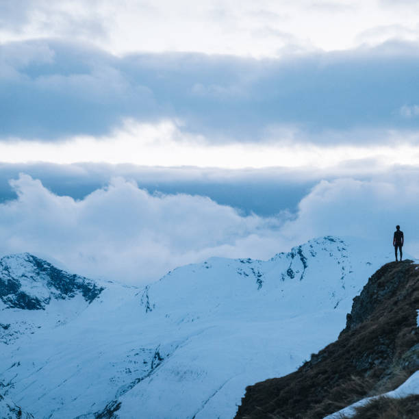 istock Trail runner relaxes on snowy mountain ridge in the morning 1290576580