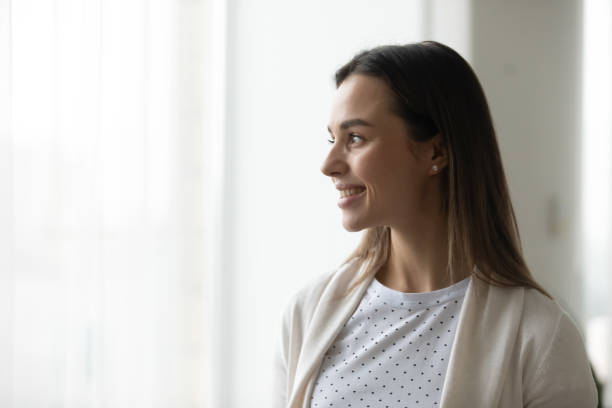 istock Smiling young woman look in distance dreaming thinking 1290576895