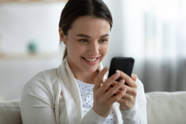 istock Smiling girl relax at home using modern smartphone gadget 1290577416