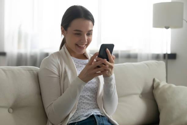 istock Smiling millennial girl relax at home using smartphone 1290577419