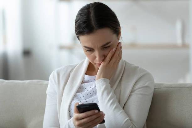 istock Unhappy young woman having problems with smartphone 1290577422