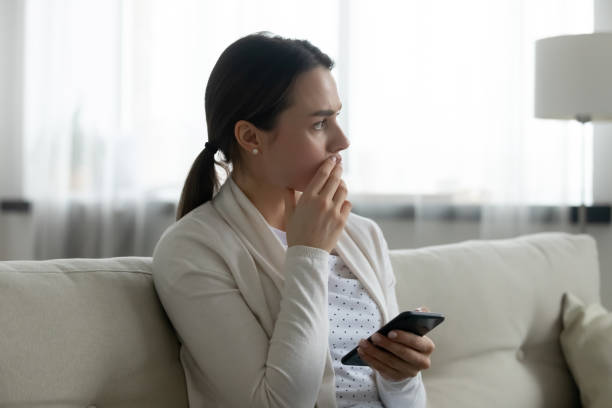 istock Worried young woman distressed with cellphone message 1290577423