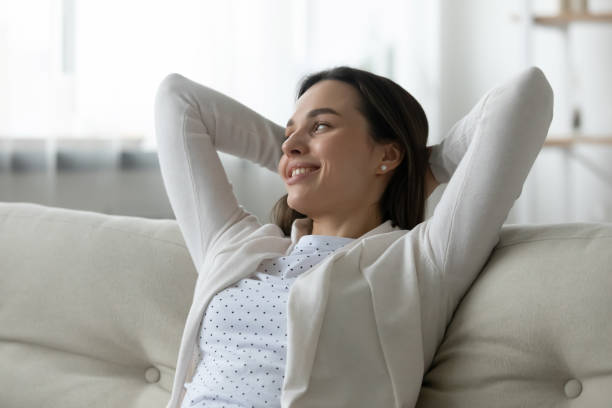 istock Happy girl relax on comfortable couch at home dreaming 1290577431