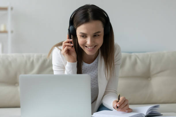 istock Smiling female student watch webinar on laptop at home 1290577462
