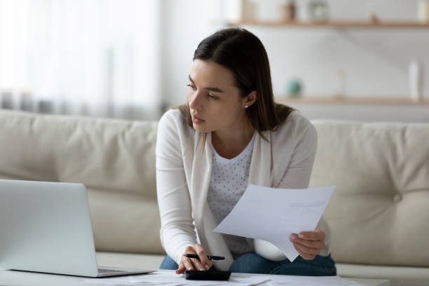 istock Young woman busy managing household budget using laptop 1290577473
