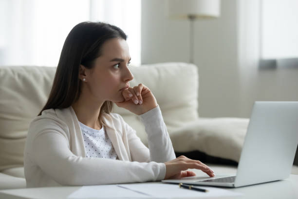 istock Pensive young woman work on laptop thinking 1290577474